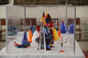 Ett stort bord med glaskonst i många olika färger.