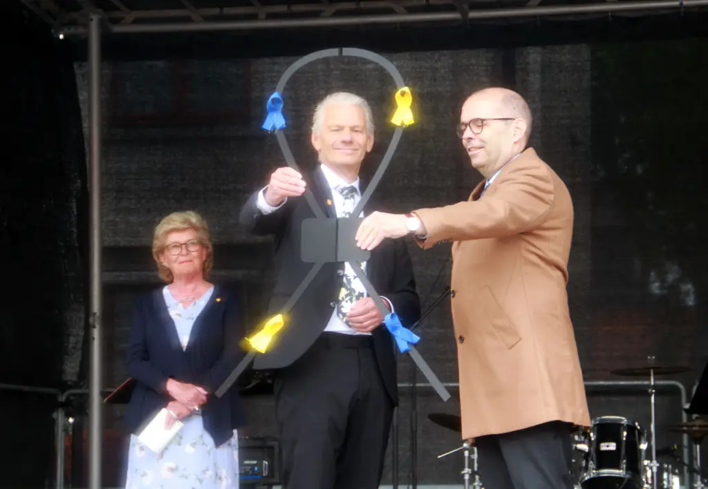 Dessie Forsén, ordförande i Vadstena Turism & Näringsliv, betraktar kommunalråd Peter Karlsson, Vadstena kommun och Landshövding Carl Fredrik Graf som för samman ett ankarjärn - för att symbolisera "en plats som ska förena och skapa möten". Foto: Björn Andersson.
