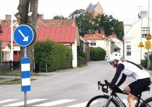 Cyklist passerar Vadstena med Rödtornet i bakgrunden