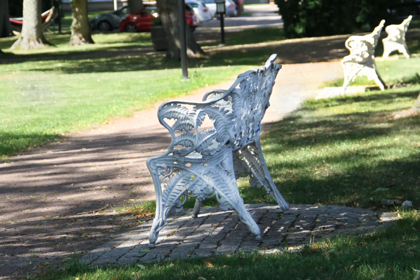 Vit parkbänk i Asylenparken