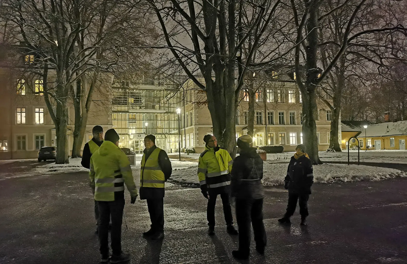 Grupp som står utanför biblioteket i kvällsmörker.