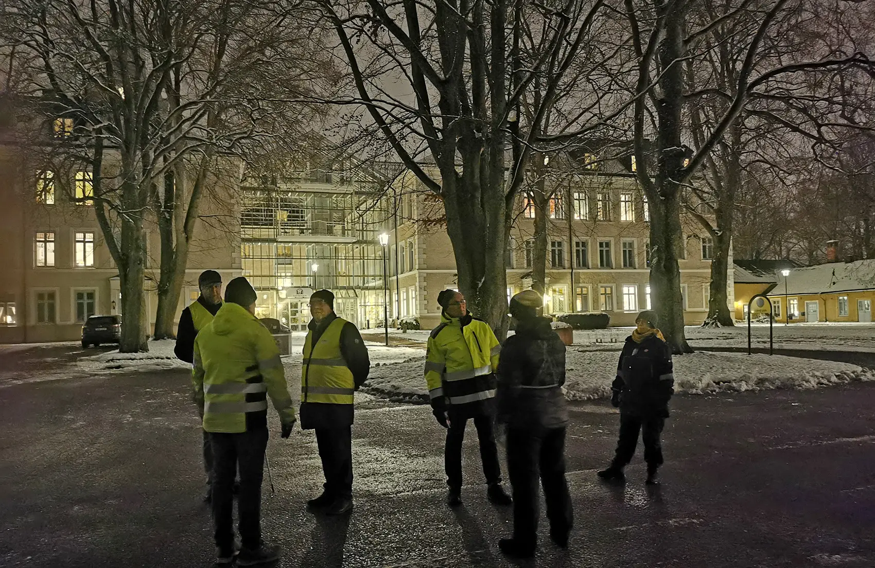 Grupp som står utanför biblioteket i kvällsmörker.