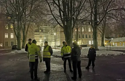 Grupp som står utanför biblioteket i kvällsmörker.
