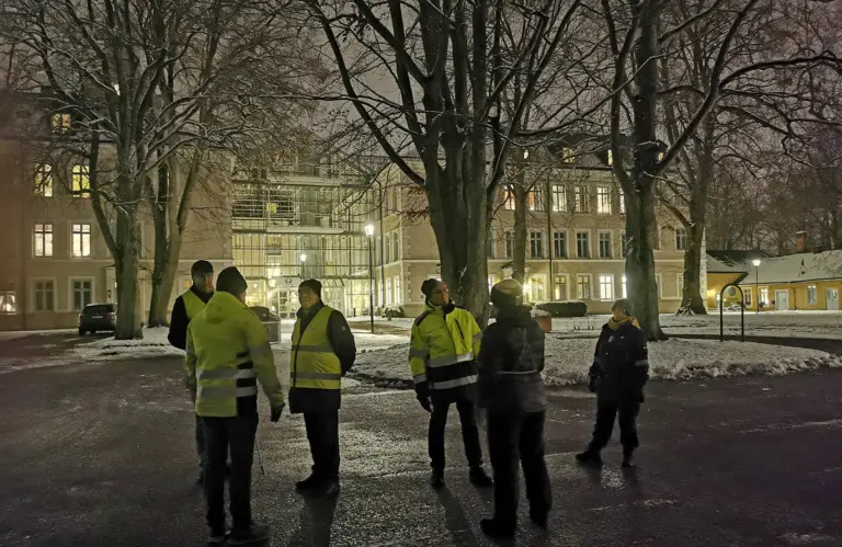 Grupp som står utanför biblioteket i kvällsmörker.