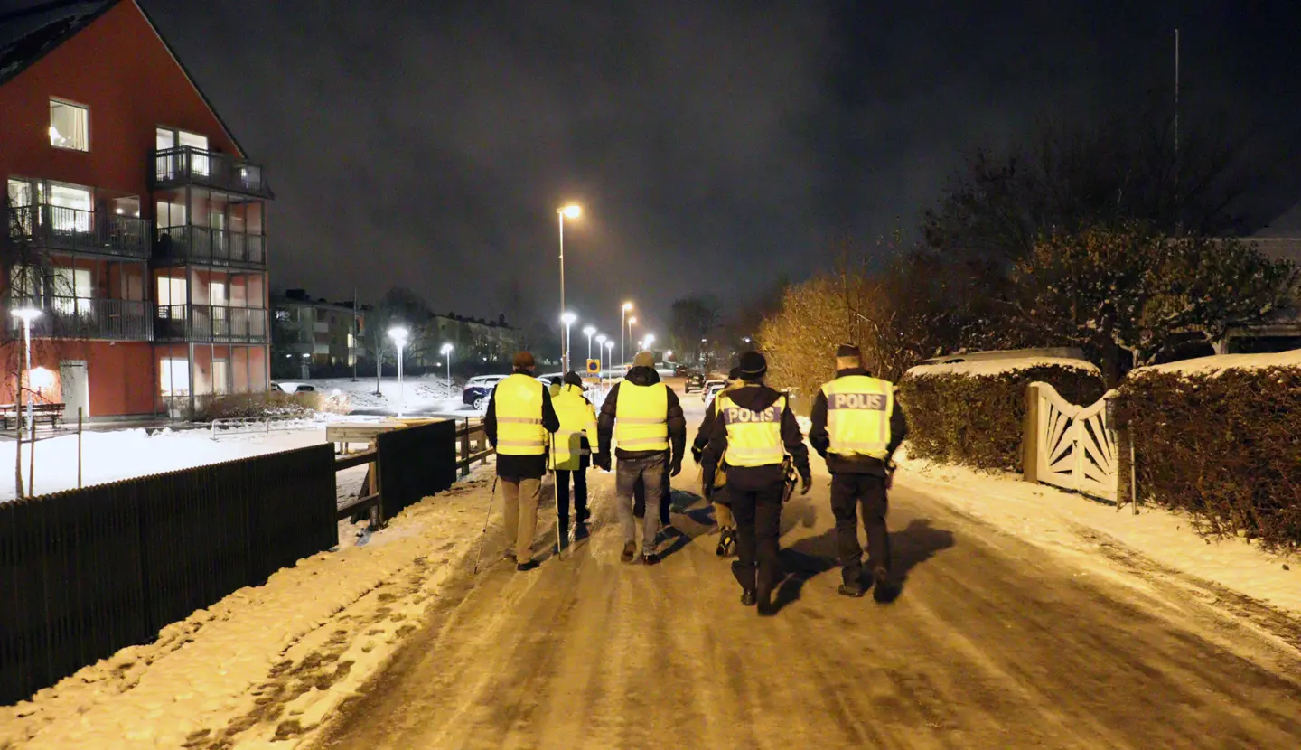En grpp människor med reflexvästar som går på en gata i Vadstena.