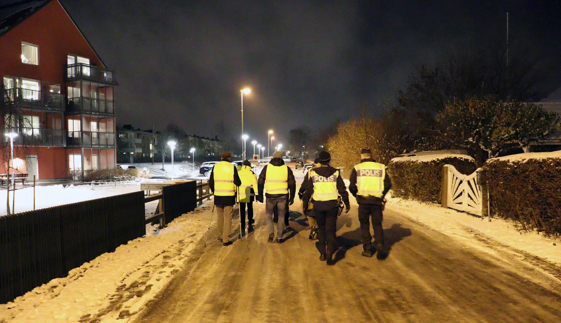 En grpp människor med reflexvästar som går på en gata i Vadstena.