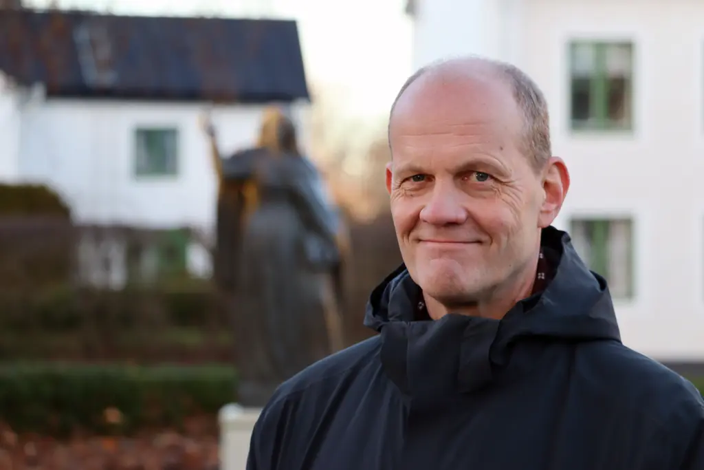 Porträttbild av Göran Fältgren framför Birgottastaty