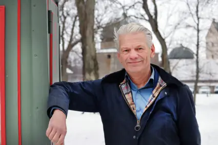 Peter Karlsson lutar sig mot gammal telefonkiosk, slottet i bakgrunden