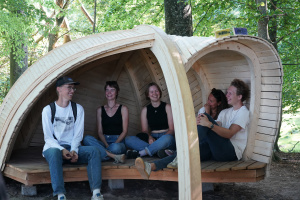 ungdomar inuti ett vindskydd byggt av trä