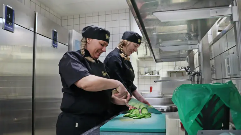 Kockarna Jenny och Matilda i arbete vid köksbänk.