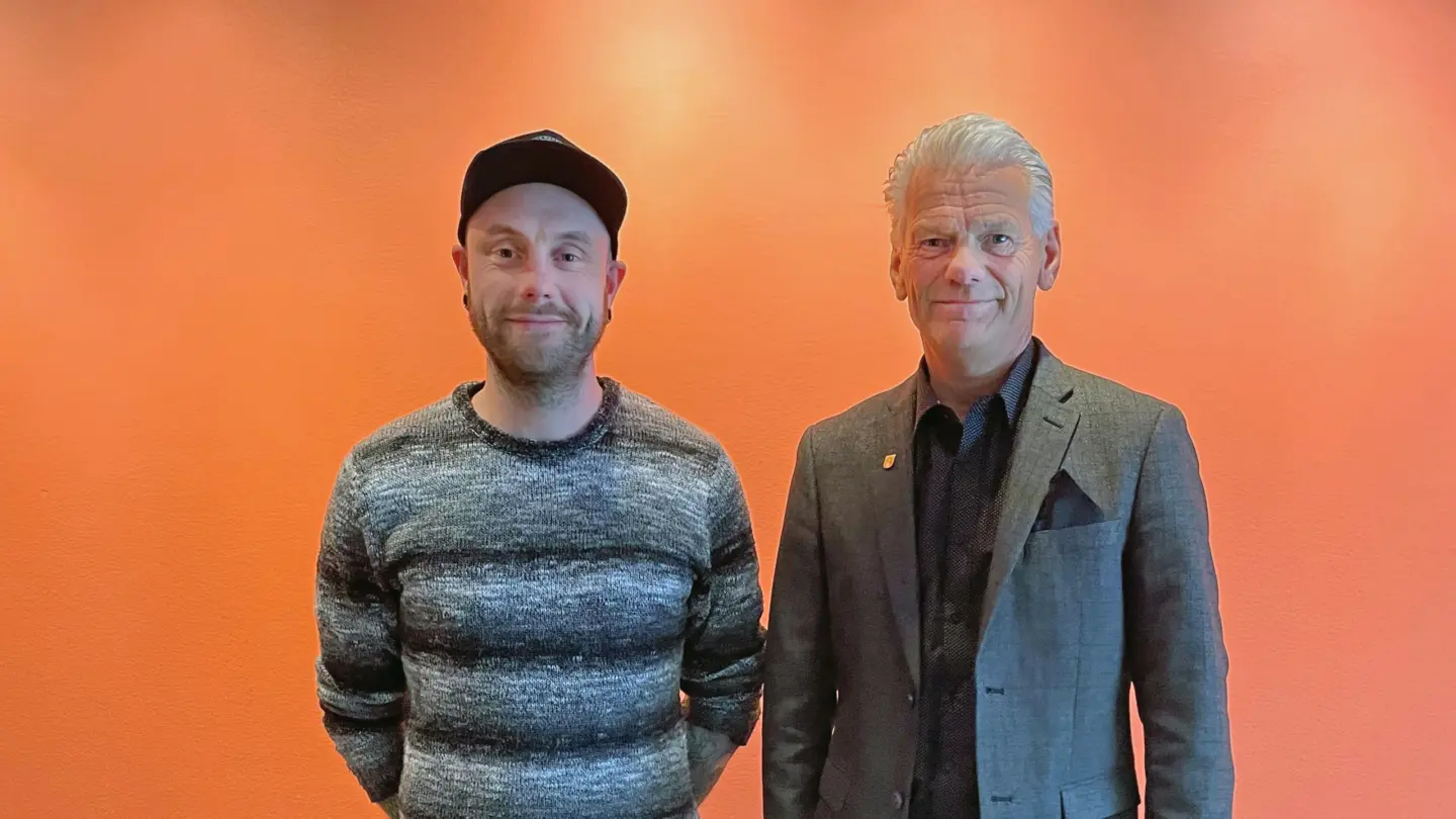 Fabian Thun och Peter Karlsson framför orange vägg.