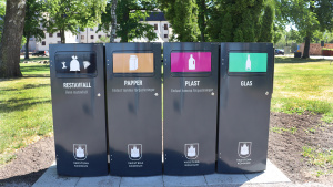 Fyra återvinningskärl i parken Myntbacken.