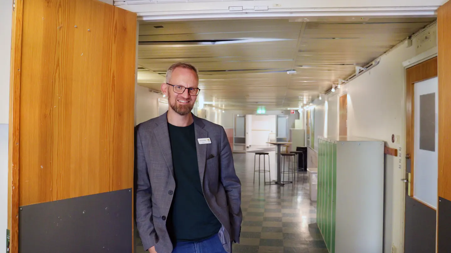 Andreas Müller står i dörröppning med skolkorridor bakom sig.