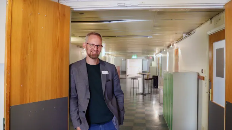 Andreas Müller står i dörröppning med skolkorridor bakom sig.