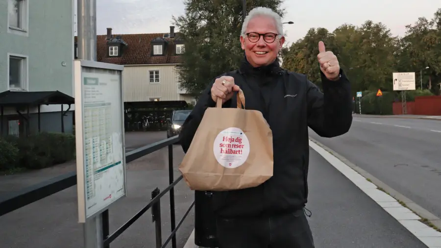 Petter gör tummen upp med frukostpåse i handen.