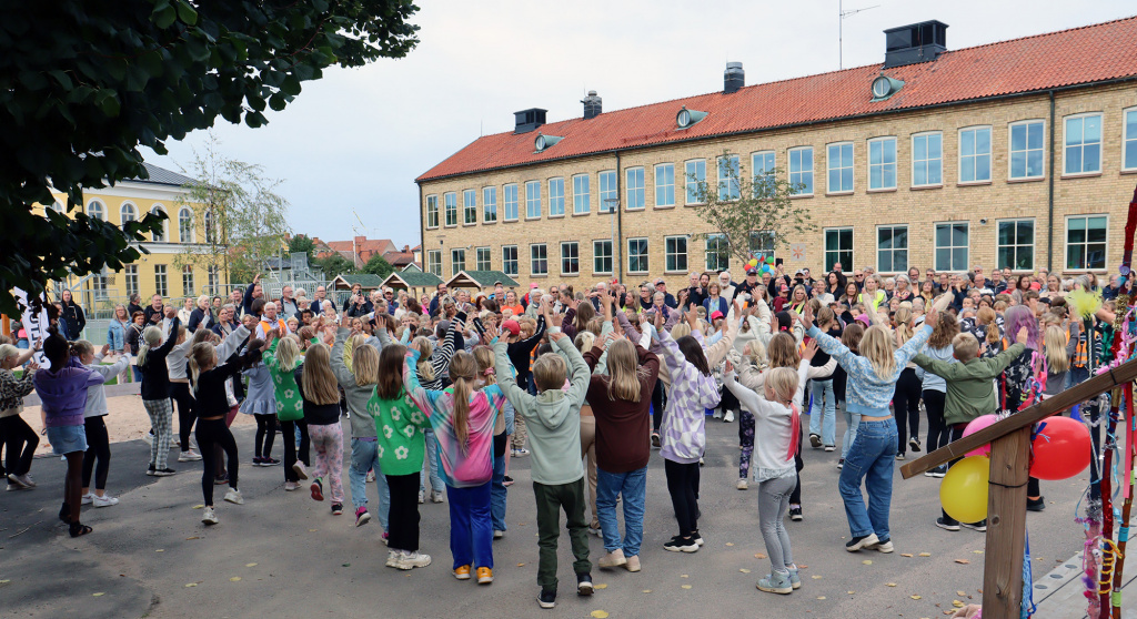 Stor grupp elever dansar inför besökarna.