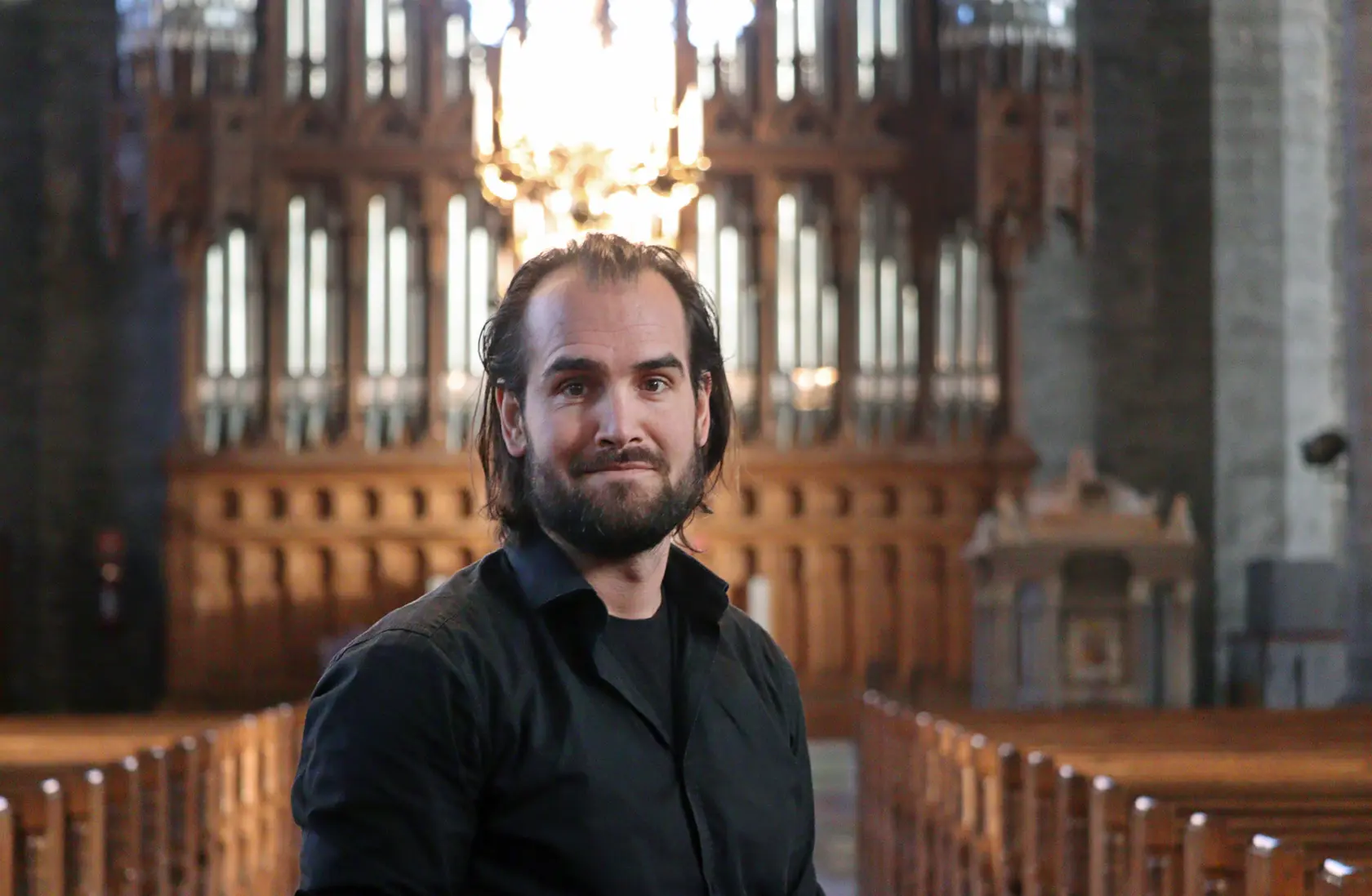 Erik i kyrkan med kyrkorgelns pipor i bakgrunden