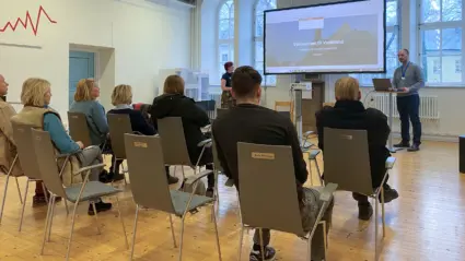Grupp människor sitter och lyssnar på föredrag
