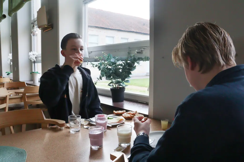 Två killar äter frukost i skolmatsal