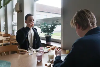 Två killar äter frukost i skolmatsal