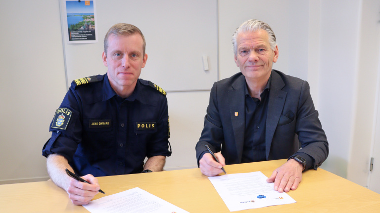 Jens Öhmark och Peter Karlsson vid ett bord med undertecknade medbrogarlöften.
