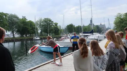 Elever tittar när lärare kastar livboj i vattnet