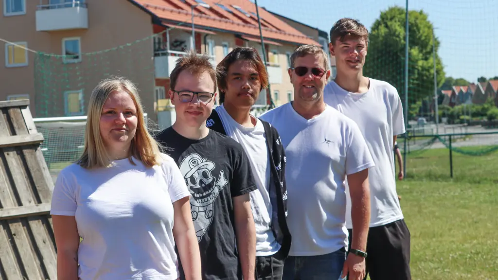 Fyra ungdomar tillsammans med fritidsledare utomhus