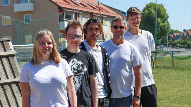 Fyra ungdomar tillsammans med fritidsledare utomhus