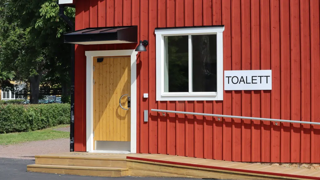 Toalettbyggnad med skylt