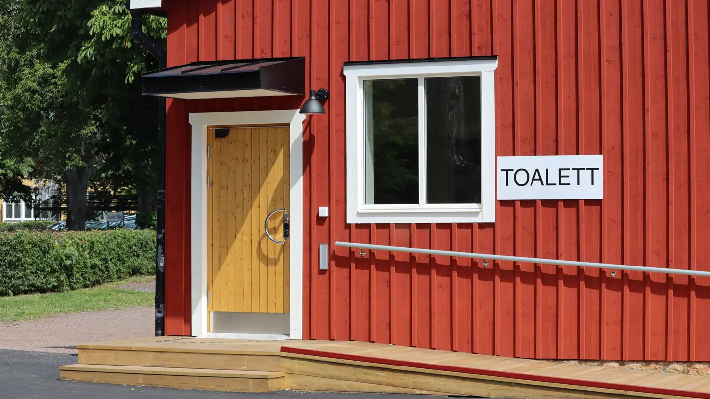 Toalettbyggnad med skylt