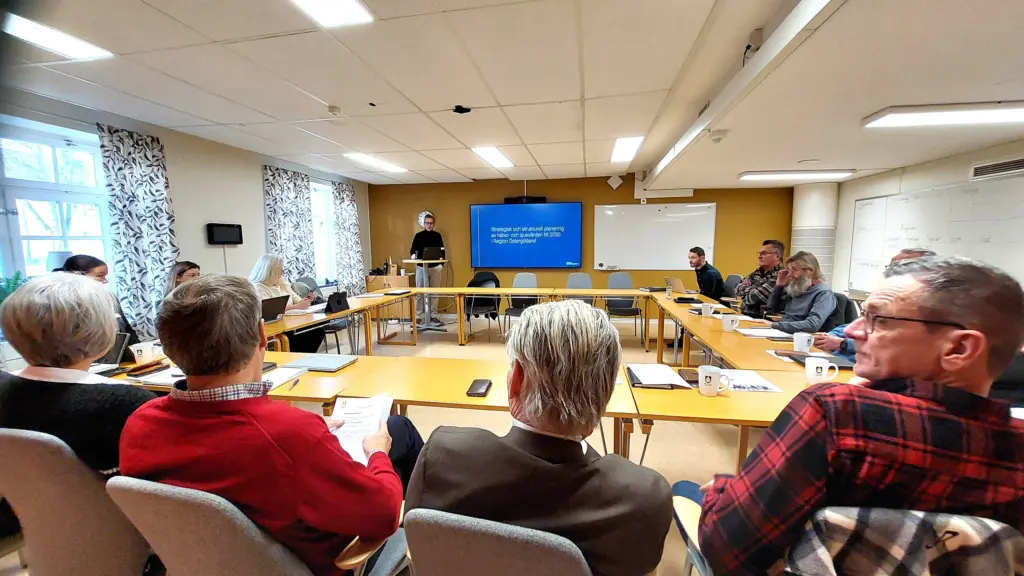 Sammanträdesrum med människor som lyssnar på föreläsare.