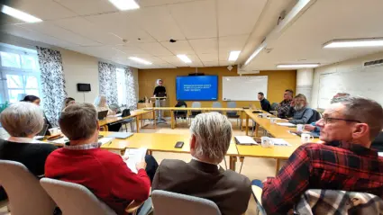 Sammanträdesrum med människor som lyssnar på föreläsare.