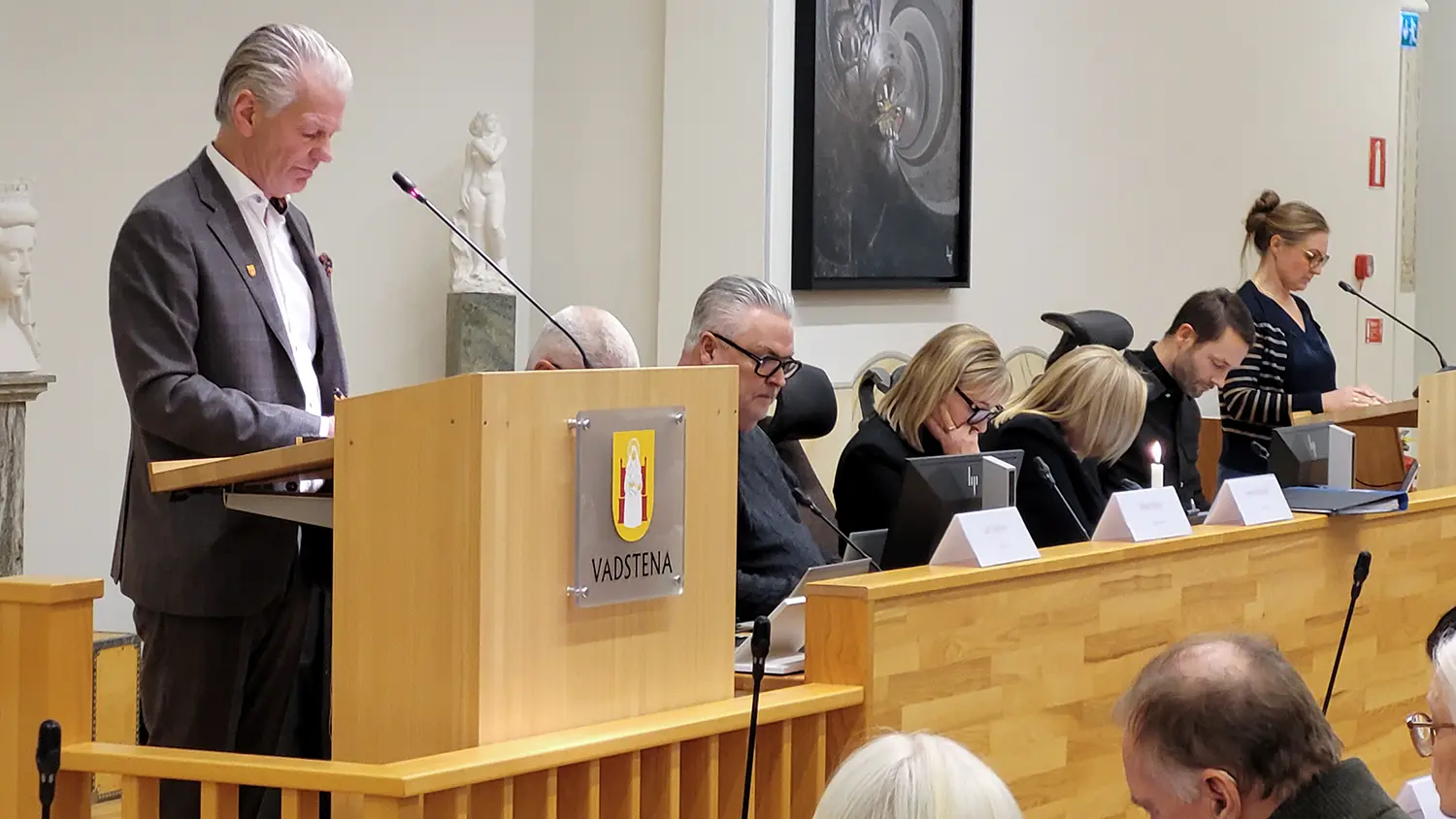 Peter Karlsson i talarstolen mad politiker runt om i kf-salen.