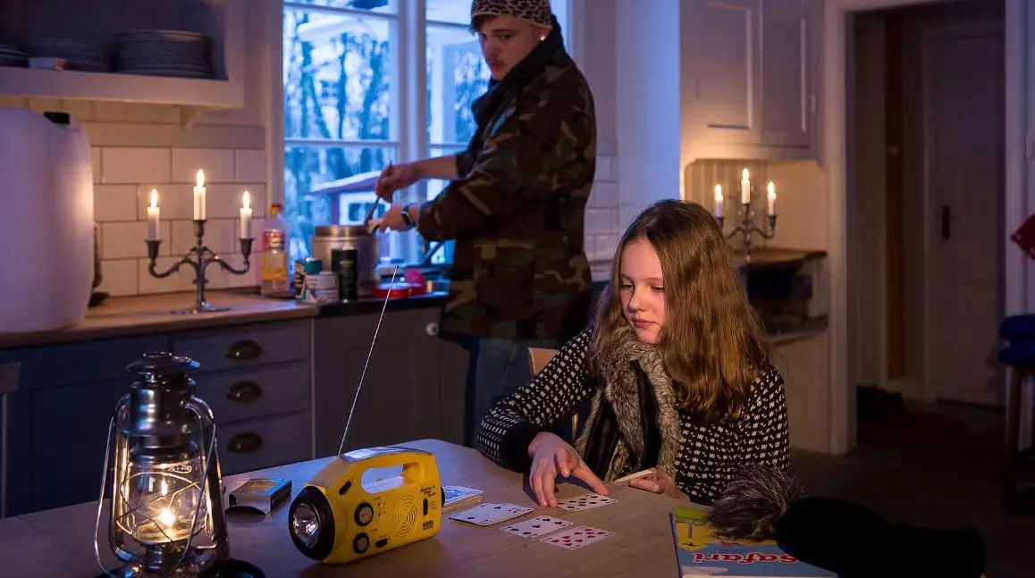 Kvinna och man i ett kök med levande ljus efter att strömmen gått,