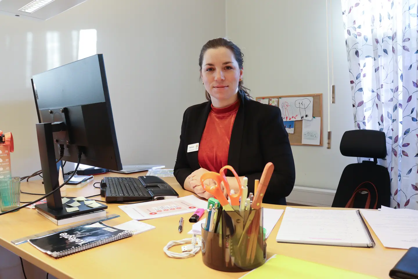 Ebba Reeder står bakom sitt skrivbord.