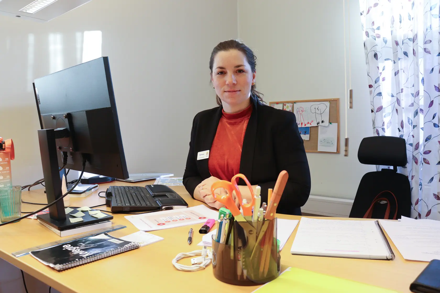 Ebba Reeder står bakom sitt skrivbord.