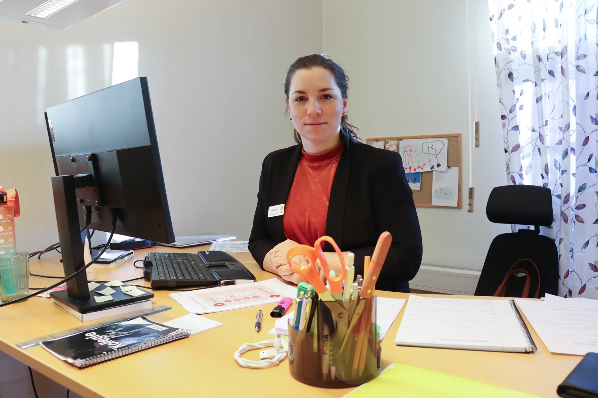 Ebba Reeder står bakom sitt skrivbord.