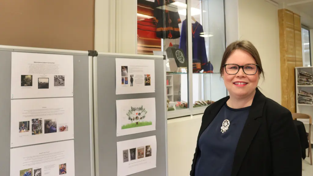Kristina framför utställningsskärmar.