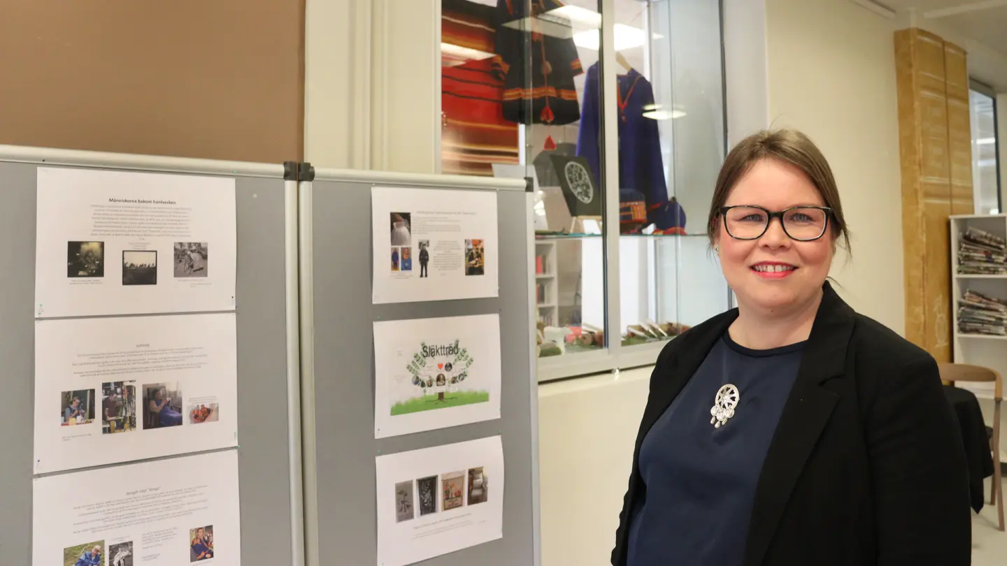 Kristina framför utställningsskärmar.