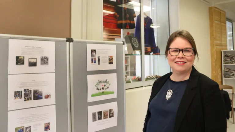 Kristina framför utställningsskärmar.