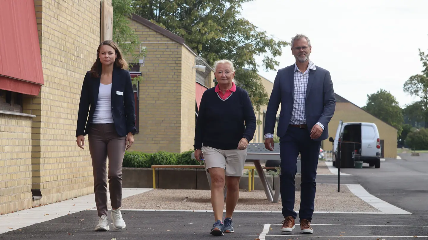 Trio går tillsammans över skolgården.