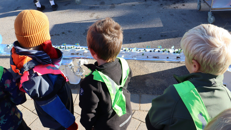 Barn står och tittar på den långa rulltårtan.