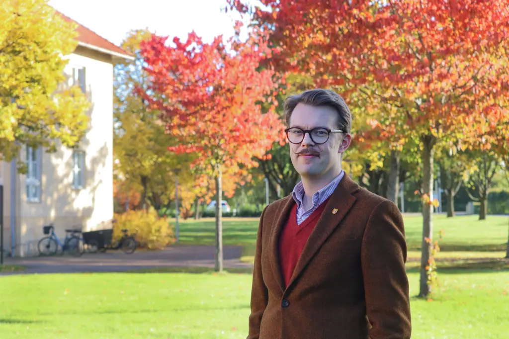Richard framför kommunhuset i höstmiljö.