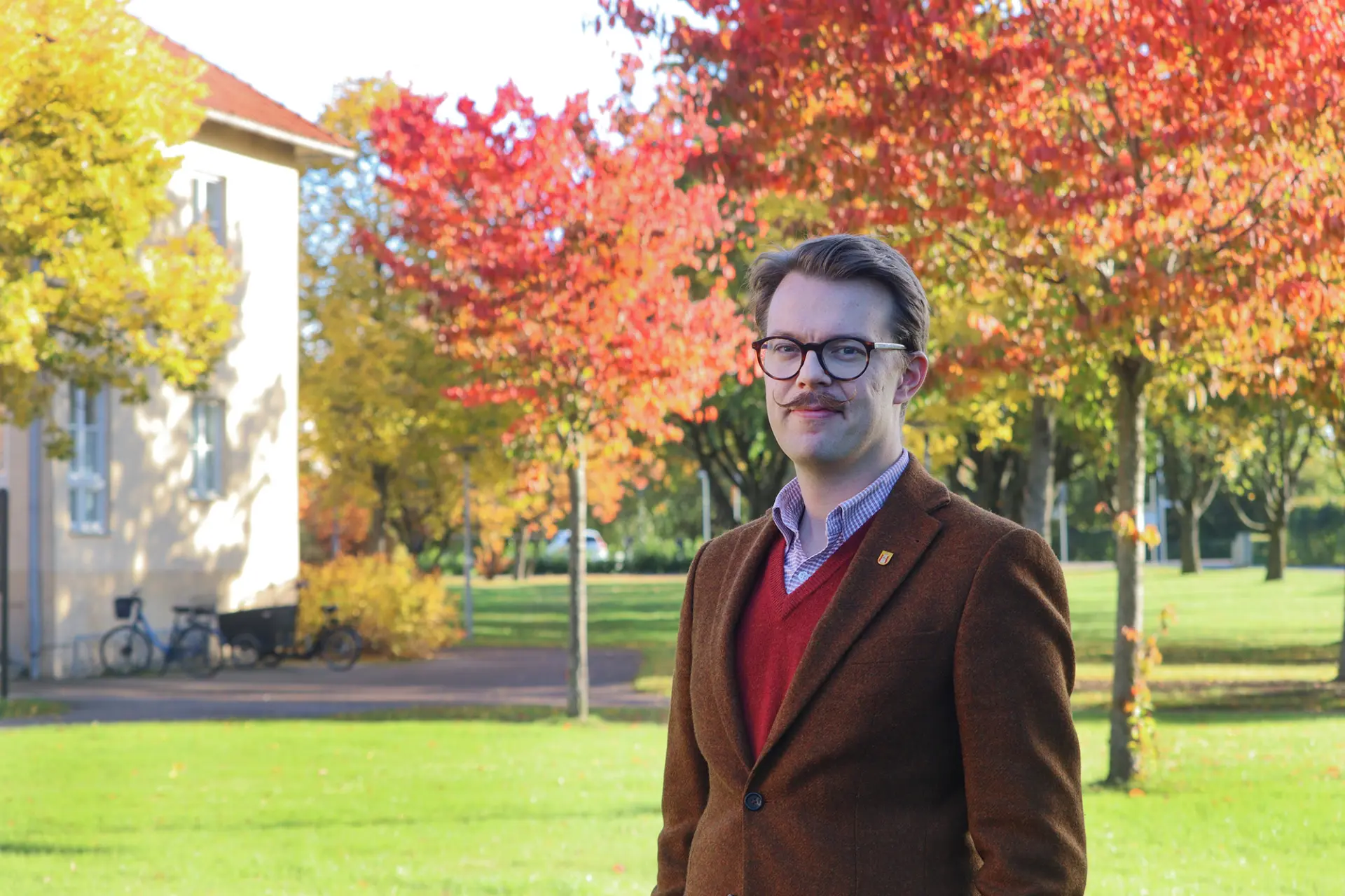 Richard framför kommunhuset i höstmiljö.