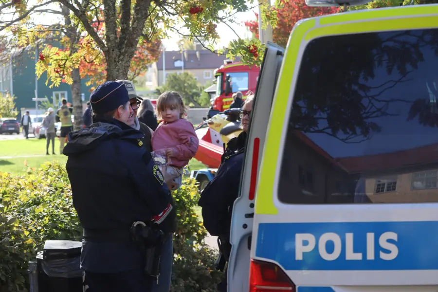 F&ouml;r&auml;lder med barn pratar med poliskvinna.